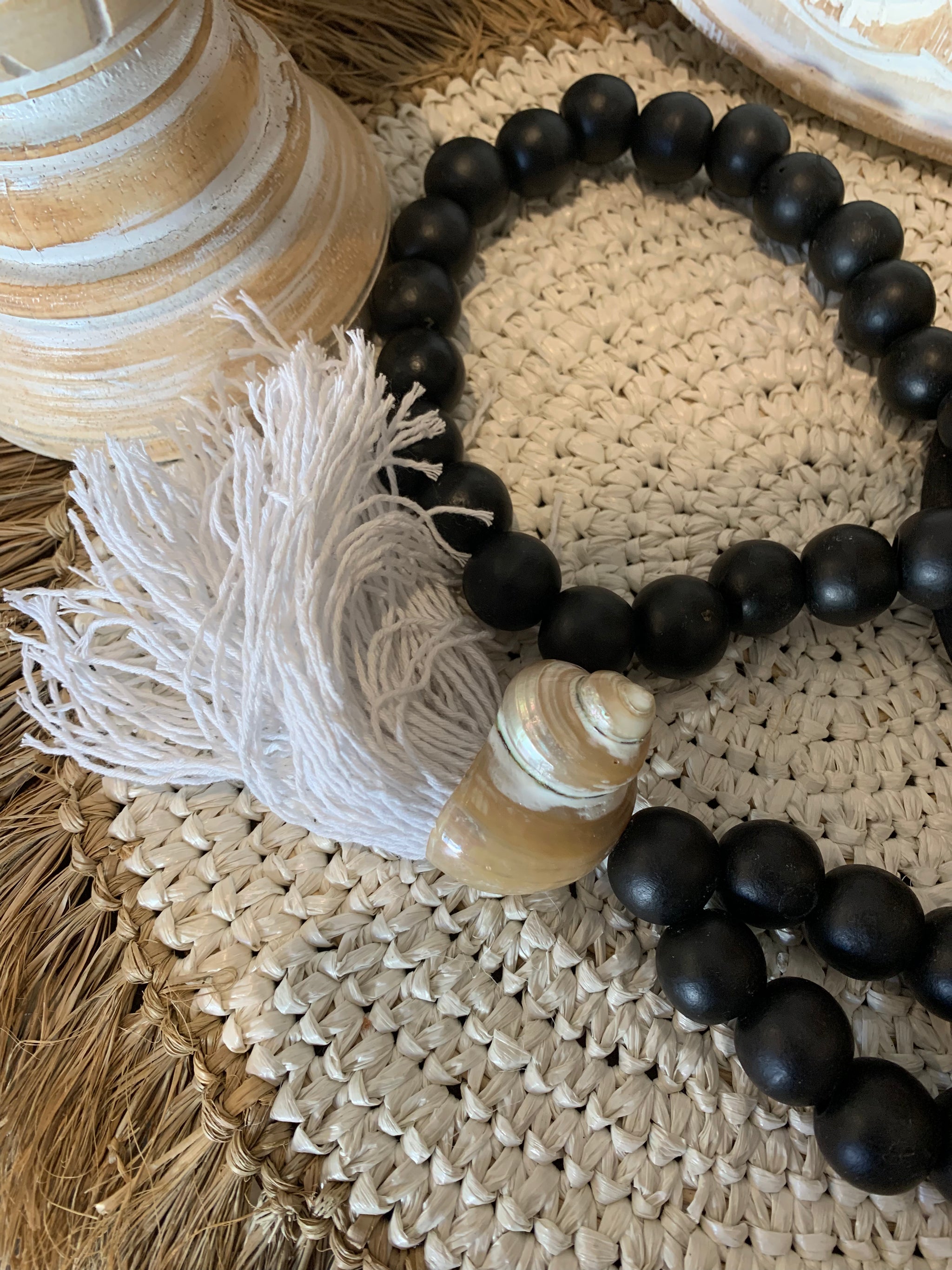Black bead necklace / tassel decoration with shell detail and white tassel. - Bali Beach Beyond