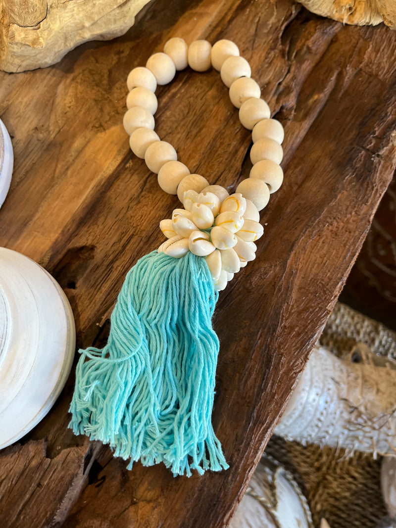 Natural bead with turquoise tassel decoration and shell detail.