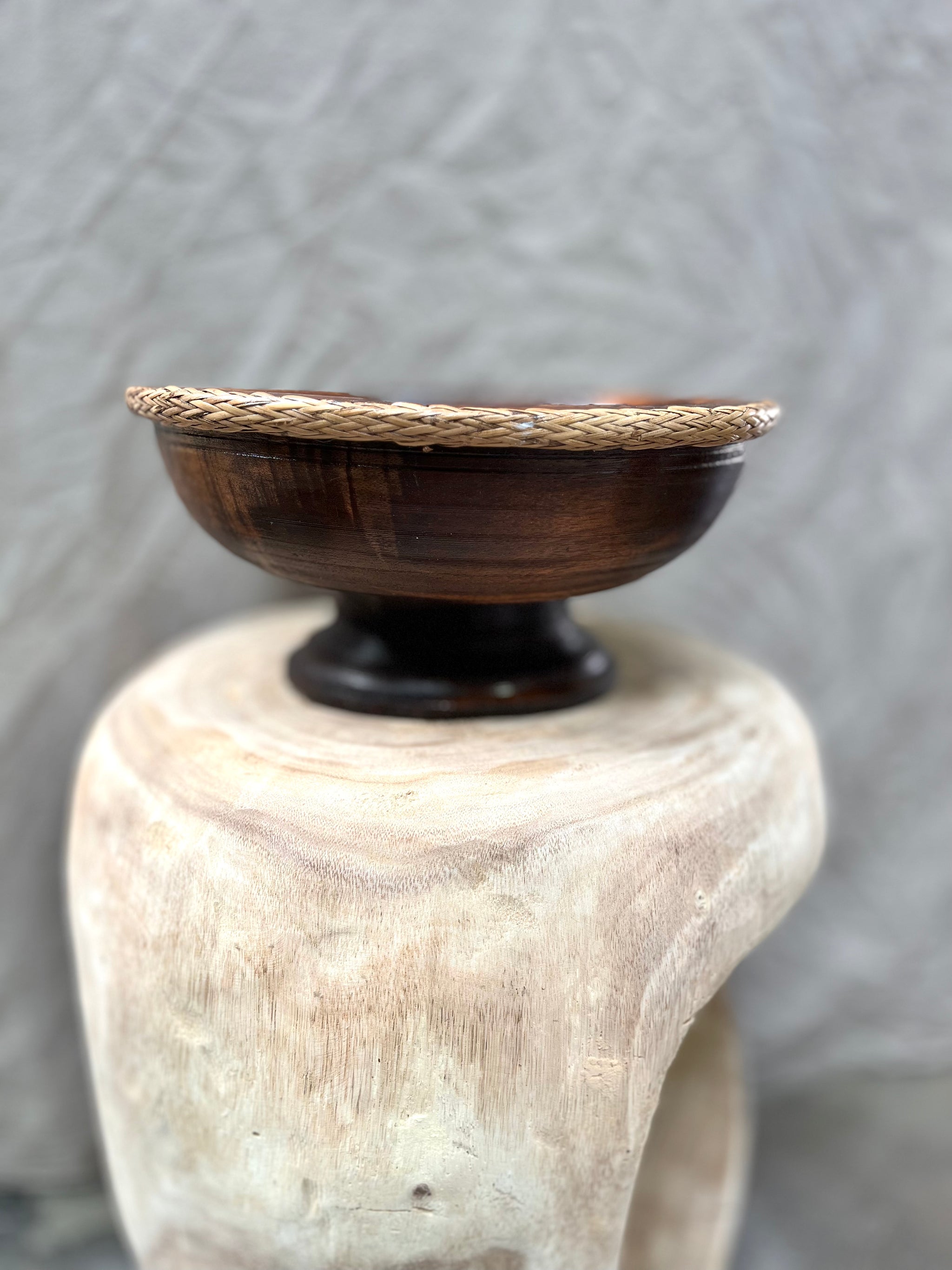 Brown timber pedestal with rattan edge detail.