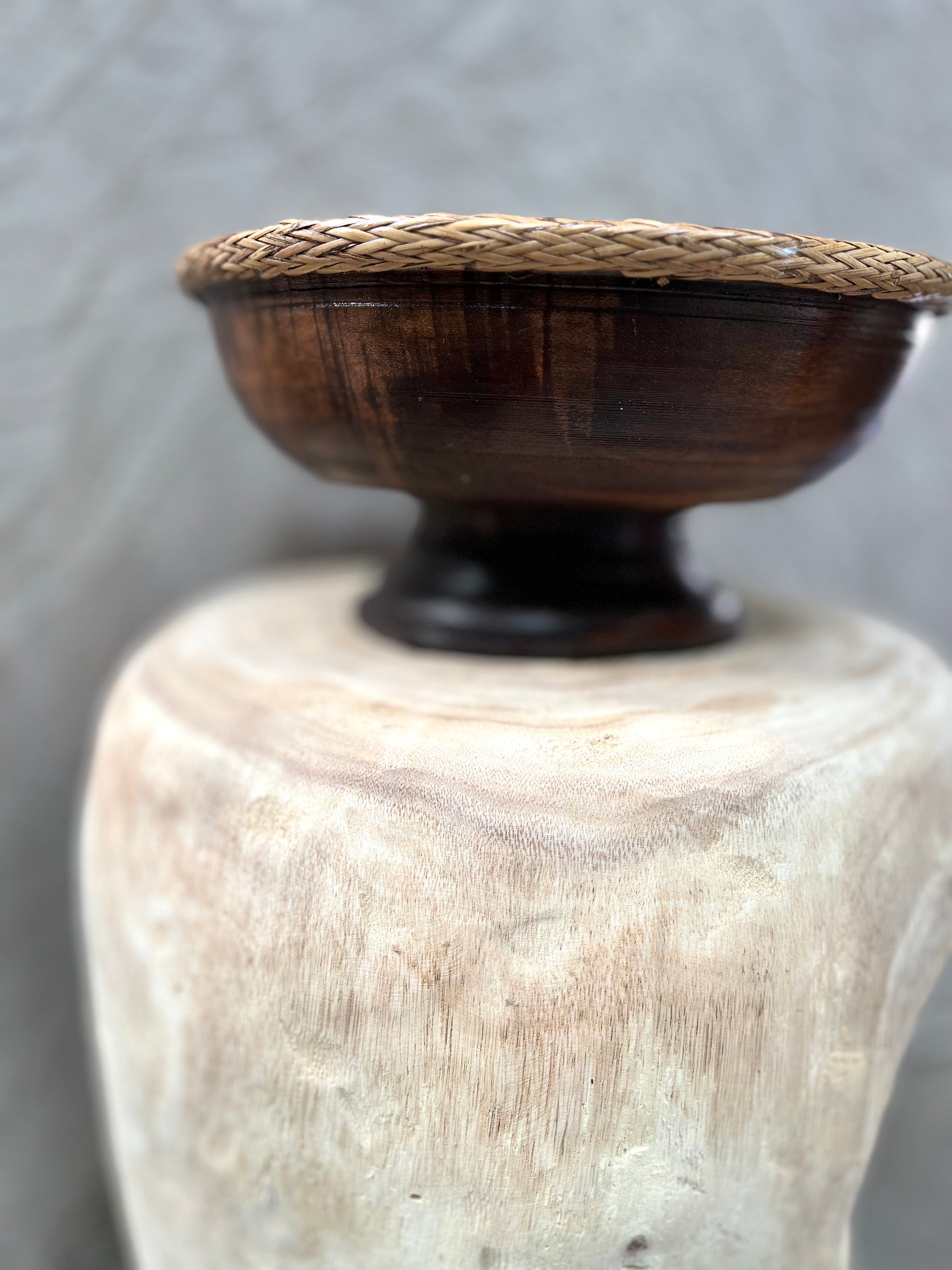 Brown timber pedestal with rattan edge detail.