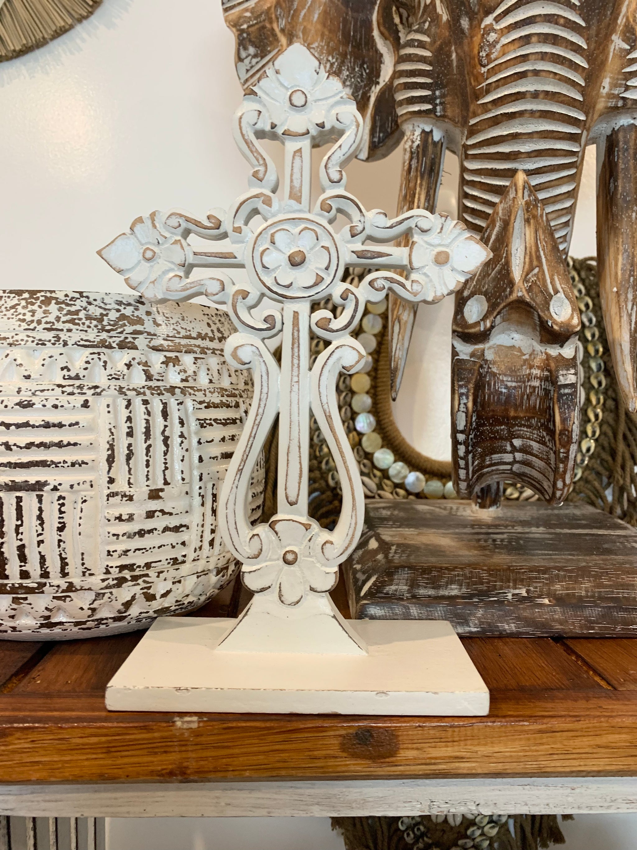 White carved cross on stand.