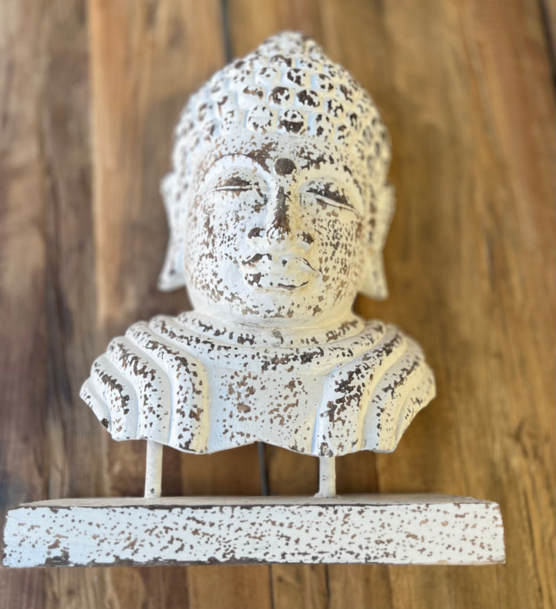 Buddha head statue on stand. Rustic white